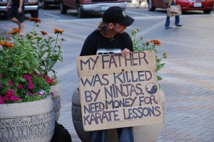 homeless guy with a sign about ninjas killing his dad