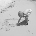 my son drawing hearts in the sand at Biloxi Beach